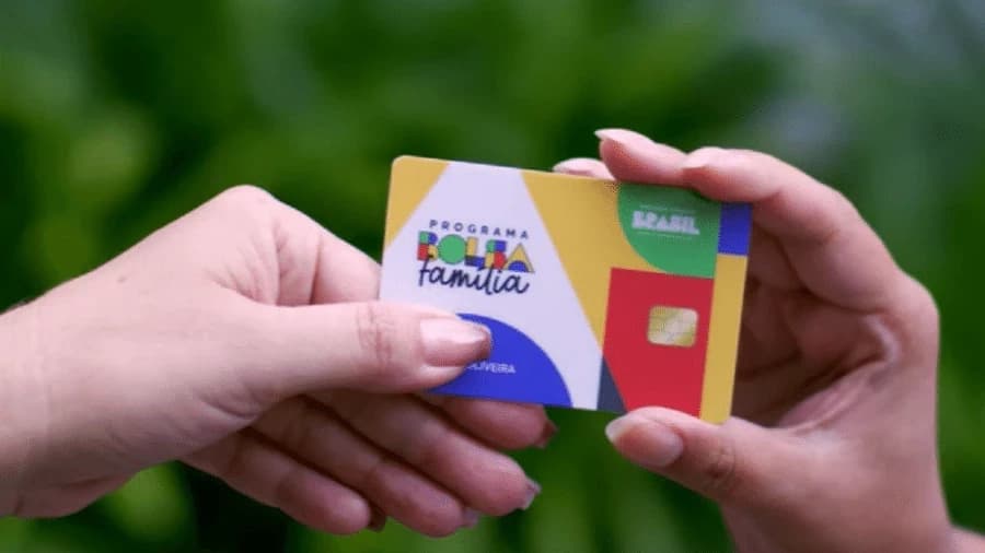 pessoa segurando cartao do bolsa familia para apostar