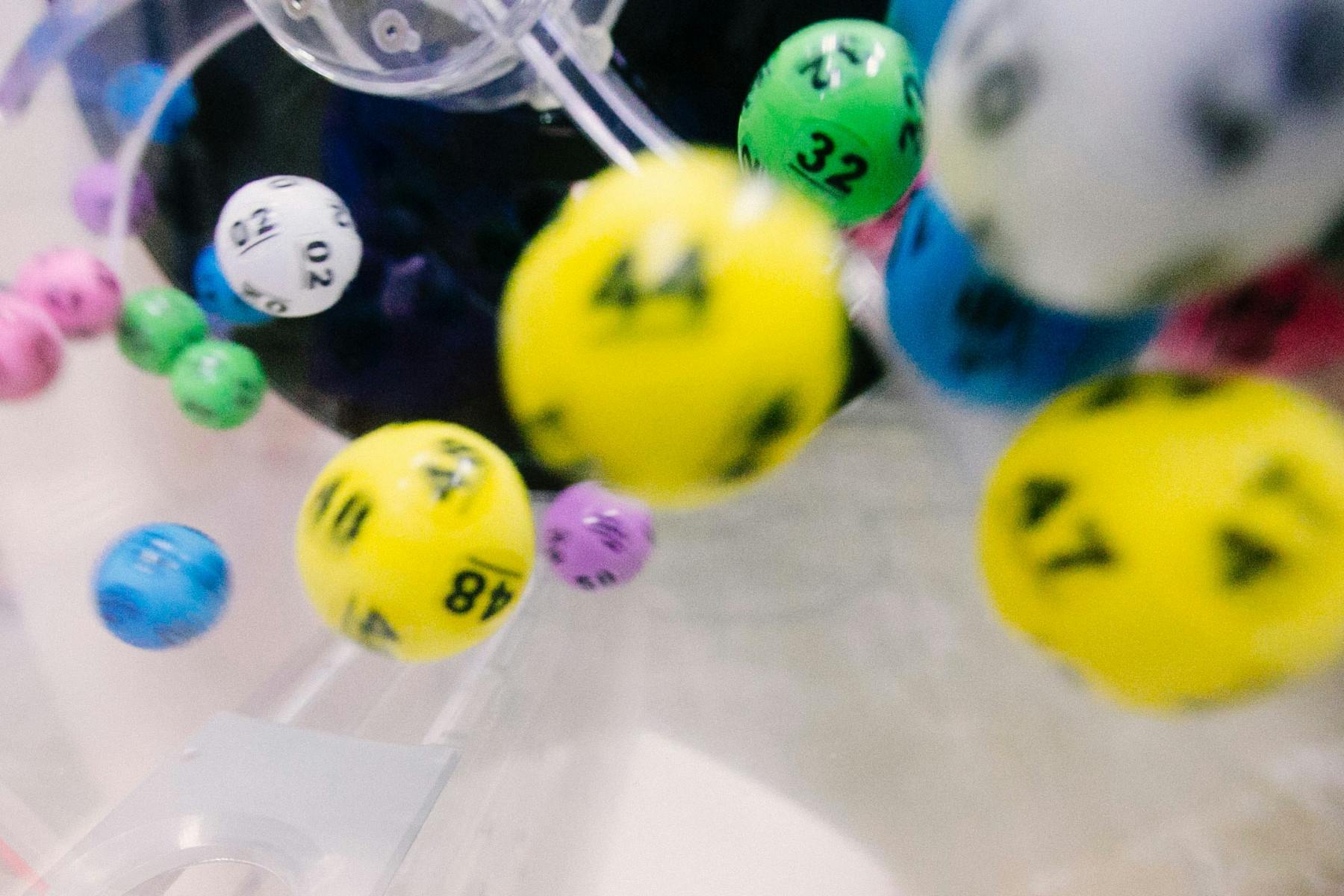 Imagem de várias bolinhas de loteria caindo em uma máquina, representando o nosso conteúdo sobre o que é bolão