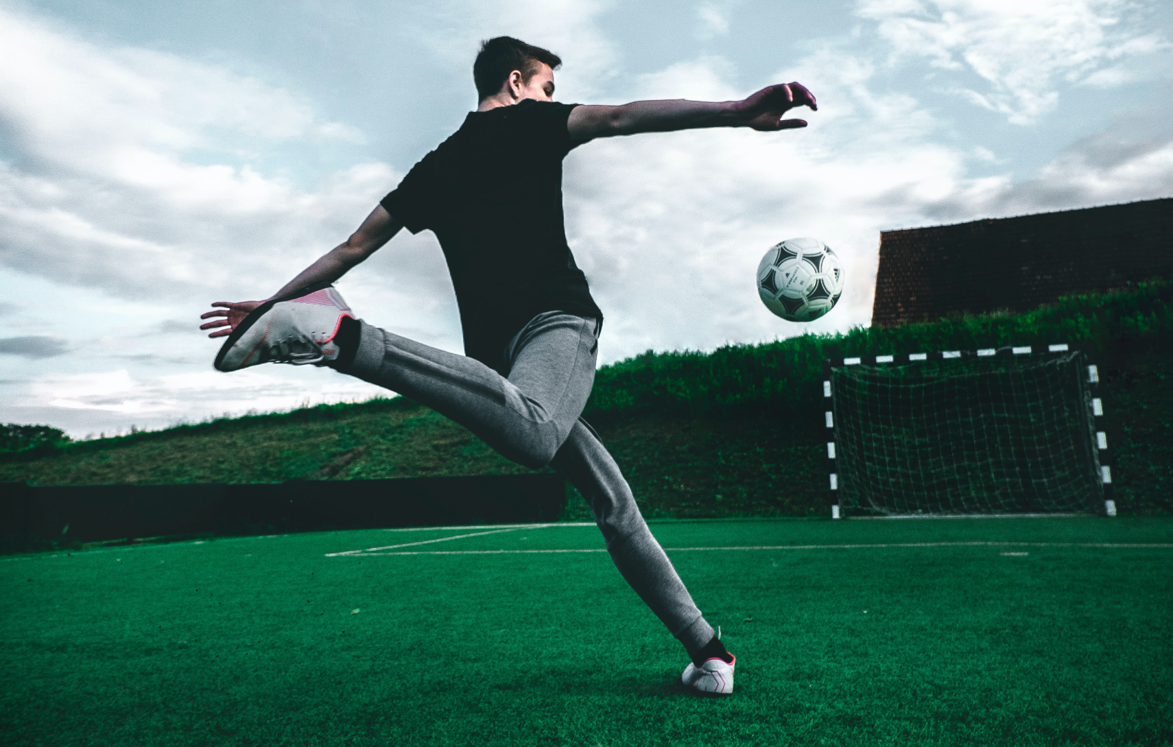 Imagem de um atleta chutando uma bola de futebol ao gol. A foto foi usada para ilustrar nosso texto sobre cash out nas apostas esportivas