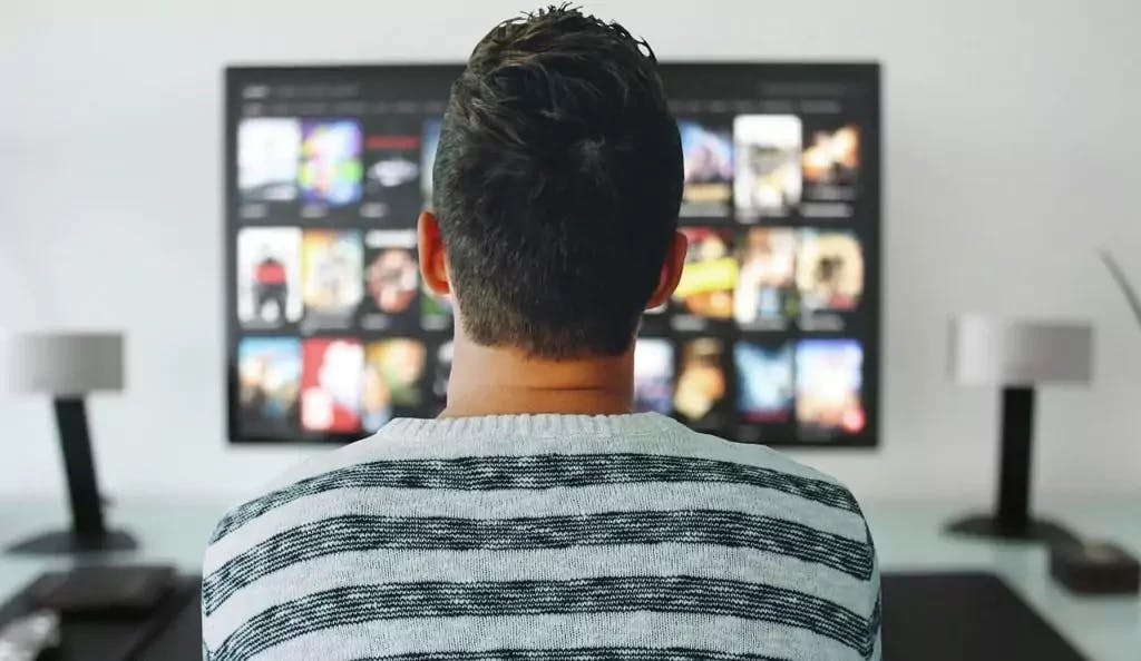 Imagem de um homem assistindo a televisão